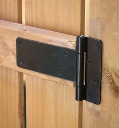 a close up of a wooden door with two black latches on the front and side