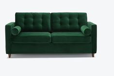 a green couch sitting on top of a white floor