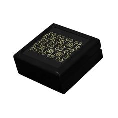 a black box with gold designs on the lid is shown in front of a white background