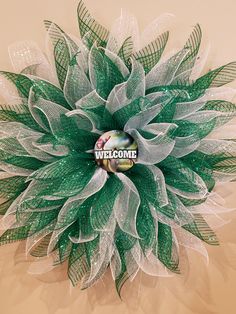 a green and white wreath with the words welcome on it