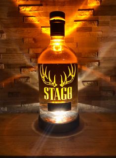 a bottle of stagg sitting on top of a wooden table next to a brick wall