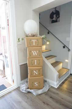 a stack of boxes sitting on top of a wooden floor next to a stair case