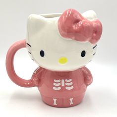 a hello kitty skeleton mug with a pink bow on it's head is shown in front of a white background