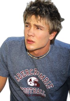 a young man wearing a gray shirt with a football helmet on it's head