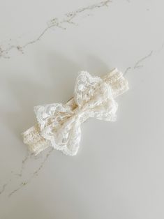 Graceful and elegant lightweight lace bow with stretchy lace headband. Approximately 7". White Bow Tie Headband, White Headband With Bow Tie, White Wedding Headband With Decorative Bow, Elegant Adjustable Hair Accessories With Decorative Bow, Adjustable White Satin Bow, Adjustable Cream Hair Accessories With Bow, White Bow Headband For Wedding, White Wedding Headband With Bow, Elegant Adjustable Bow Hair Accessories