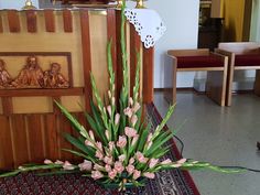 a vase filled with pink flowers sitting on top of a rug