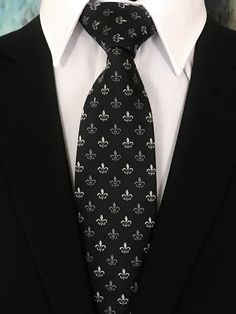 "Perfect for a black tie wedding. This black tie with Fleur De Lis design is a classic must have tie. Available as a extra long neck tie. Handmade from 100% silk, this special collection features a .75\" Eds Neckties logo at the bottom right front corner of every tie and a larger logo located on the tipping (Back of the tie). The label features the collection name (Nathaniel Alexandria) Named after my son Nathaniel and my daughter Alexandria. Expertly hand-made from 100% silk you can select your Silver Ties For Black Tie Events, Classic Fitted Silver Suit And Tie Accessories, Luxury Fitted Ties For Wedding, Silver Standard Tie For Black Tie Events, Classic Silver Tie For Business, Elegant Fitted Silver Suit And Tie Accessories, Silver Suit And Tie Accessories For Black-tie Events, Elegant Silver Suit And Tie Accessories For Party, Elegant Tie Accessories For Black-tie Events