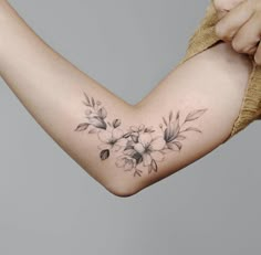 a woman's arm with flowers on it