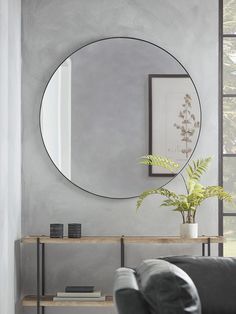 a living room with a couch and a round mirror