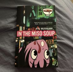 a book with an image of a pink octopus on it's cover sitting on a bed