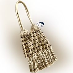 a white bag with tassels hanging from it's side on a white background