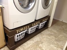 two washers stacked on top of each other in front of a dryer door