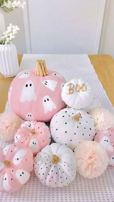 pink and white pumpkins are arranged on a table