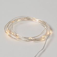 the white string lights are connected to each other on a gray surface, with one wire running through it