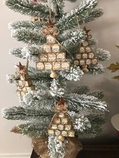 a christmas tree with ornaments hanging from it's branches and decorations on the top