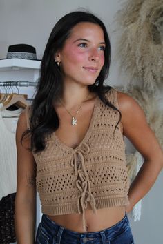 Elevate your wardrobe with our chic crochet vest top, designed for effortless style and comfort. This sleeveless piece features a playful tie-front detail and a flattering plunging V-neckline, adding a touch of sophistication to your look. The delicate crochet pattern adds texture and a hint of bohemian flair, perfect for layering or wearing solo. Ideal for warm weather or a sun-soaked getaway, this vest top effortlessly combines fashion and function. for reference Karlee is 5’8 and wearing a si V-neck Tie Back Tank Top For Beach, Chic V-neck Knit Top For Vacation, Sleeveless Top With Drawstring Tie For Vacation, V-neck Open Knit Tank Top, Spring V-neck Open Knit Tank Top, Chic V-neck Crochet Top For Day Out, Spring Vacation V-neck Sweater Vest, Sleeveless Tie-waist Tops For Vacation, Chic Knit Sweater Vest For Vacation