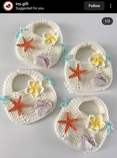 four crocheted baby bibs with starfish and shells on them