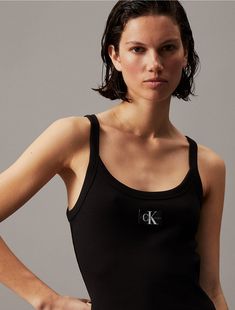 Crafted from a soft cotton stretch blend, this tank dress is a key piece for everyday outfits. Cut in a close fit with a fine ribbed texture that flatters your form. Styled with a scoopneck and features a woven CK monogram logo tag at the chest.  Material: 94% Cotton, 6% Elastane. Ck Monogram, Plus Size Sports Bras, Mini Tank Dress, Blazer Shirt, Logo Tag, Ribbed Texture, Jumper Shirt, Swimwear Outfit, Suit Shop