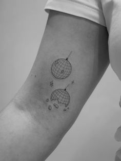 a woman's arm with two small globes on the back of her left arm