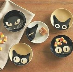 black cat plates and bowls with candy on them