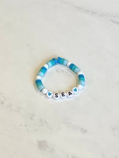 A (2 inches wide) Sea friendship bracelet. With beads colored dark blue, turquoise and light blue. Light Blue Friendship Bracelet, Adjustable Blue Name Bracelet With Colorful Beads, Blue Name Bracelet With Colorful Beads As Gift, Blue Name Bracelet With Colorful Round Beads, Blue Name Bracelet With Colorful Beads, Blue Letter Beads Bracelet For The Beach, Blue Letter Beads Bracelet For Beach, Blue Letter Beads Bracelets For Beach, Blue Bracelet With Letter Beads