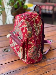 a red backpack sitting on top of a wooden table