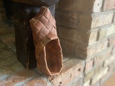 a piece of leather sitting on top of a brick wall