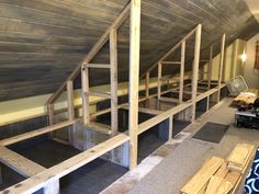 there are bunk beds in the attic with no mattresses on them, and one bed is made out of wood