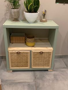 a green shelf with baskets and plants on top