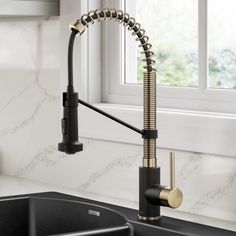 a kitchen sink and faucet in front of a window