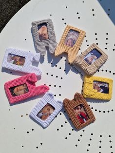 small knitted photo frames sitting on top of a white table with polka dot dots