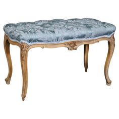 an antique bench with blue velvet upholstered seat