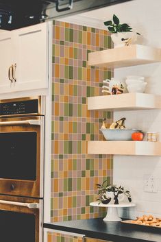 a kitchen with tiled walls and shelves above the stove