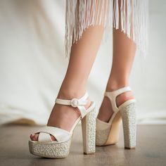 a woman's legs wearing high heels and white shoes