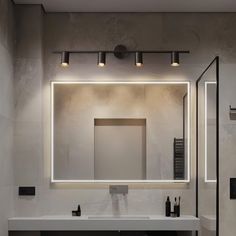 a bathroom with a sink, mirror and lights on the wall in front of it