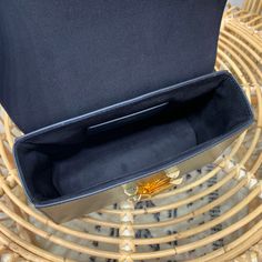 a black purse sitting on top of a wicker chair