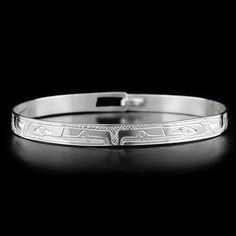 This elegant silver clasp bracelet has been hand crafted by Coast Salish artist Gilbert Pat using sterling silver. There are two depictions of the Raven that have been craved into the surface of the band. Band width is 1/4" and length is 7 1/2". EAGLES SYMBOLIZE: POWER, INTELLIGENCE, VISION The Eagle is one of the most popular in Native art and mythology. In many regions, Eagle clan families are traditionally very prominent and Eagle Chiefs are the most powerful. Eagle is used to represent perce Classic Round Cuff Bracelet For Ceremonial Occasions, Classic Round Ceremonial Cuff Bracelet, Classic Ceremonial Hallmarked Bracelets, Classic Etched Bracelet Jewelry, Classic Etched Bracelets As A Gift, Classic Etched Bracelets As Gift, Adjustable Etched Round Bracelets, Classic Adjustable Etched Bangle, Adjustable Round Etched Bracelets