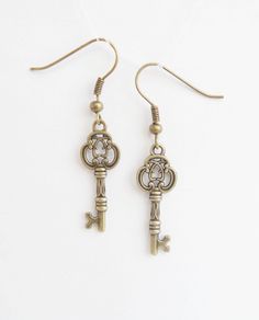 Bronze Key Earrings   Earrings are made using antiqued bronze . The vintage style ornate skeleton keys dangle from tiny but detailed infinity knots which are attached to bronze effect french earwires for pierced ears. They are reasonably small and suitable for everyday wear. I wear my own pair quite a lot as they go with pretty much anything vintage style. length - 3,5 cm Earrings: https://www.etsy.com/shop/NewJewelleryStory?ref=seller-platform-mcnav&section_id=17110923 Stud earrings: https://ww Key Earrings Aesthetic, Antique Gold Metal Earrings With Antique Finish, Nickel Free Brass Steampunk Earrings, Steampunk Nickel-free Brass Earrings, Steampunk Brass Nickel-free Earrings, Antique Earrings Studs, Skeleton Key Jewelry, Key Earrings, Large Gift Boxes