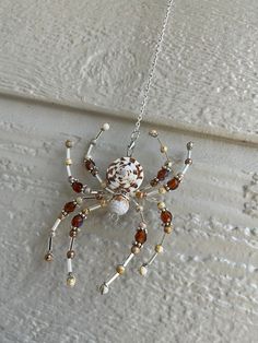 a spider is hanging from a chain with beads