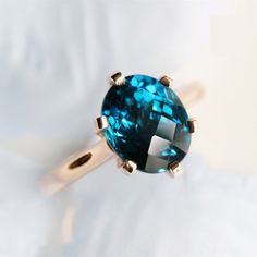 a blue ring sitting on top of a white sheet with a diamond in the middle