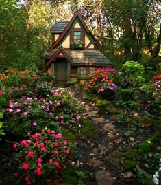 a small house surrounded by flowers and trees