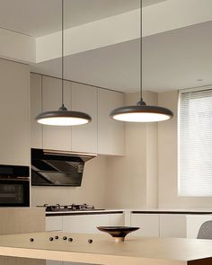 a kitchen with two lights hanging from the ceiling