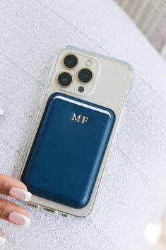 a person is holding an iphone case with the initials on it in gold and blue