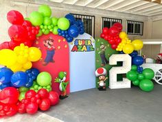 an entrance decorated with balloons and mario's 2nd birthday decorations for a party at the children's play area