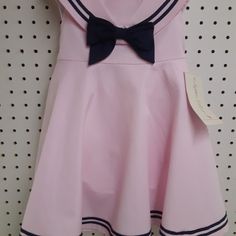 Cute Brand New With Tag Sophia Rose Sleeveless Pink Sailor Collar Dress. In Pink And Navy Blue....Has Separate Panties To Go Along With It. Zippered Back And Ties..........Size 18 Mos Measures: 8" Shoulder To Shoulder (Not Collar) .......9.5" Underarm To Underarm.......19" Shoulder To Bottom Of Dress. Has Nice Square Collar, Big Navy Bow, And Navy Stripe Trim Around Collar And Bottom Of Dress. Made Of 60% Cotton And 40% Polyester. Preppy Pink Dress For Spring, Preppy Pink Spring Dress, Pink Cotton School Dress, Fitted Pink Dress For School, Pink Cotton Dress For School, Preppy Pink School Dress, Preppy Pink Summer Dress, Pink Preppy Cotton Dress, Preppy Pink Sleeveless Dress