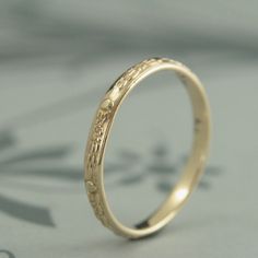 Like tiny waterlilies floating around your finger, our Monet band features a vintage style floral motif encircling the entire ring. Hand made in solid 14K yellow gold, this band measures 2.5mm wide by 1.3mm thick. This makes it a perfect sized wedding band that will last for generations. Your ring will be custom made to size just for you and given a meticulously hand polished finish. For this ring in 14K white gold: https://www.etsy.com/listing/466475336 14k Gold Band Jewelry For Wedding, Wedding Band Ring Hallmarked, 14k Gold Engraved Wedding Ring Hallmarked, 14k Gold Engraved Ring With Intricate Design For Wedding, Round Engraved 14k Gold Wedding Ring, Wedding Engraved Ring With Intricate Design In 14k Gold, Hallmarked Round Band Engraved Wedding Ring, 14k Gold Engraved Wedding Ring With Intricate Design, 14k Gold Engraved Ring For Marriage