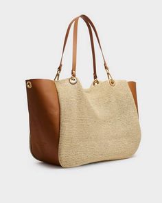 Our popular Revival Tote, reimagined. Featuring classic details such as circle grommets and dog clip hardware, this versatile tote is updated in wrap-around leather with straw front panels and light brushed gold finish. Detachable crossbody strap and interior leather pouch add customizable features. rag & bone Women's Extra Large Paper Straw Revival Summer City Tote Bag | Natural Beige. Rb Logo, Extra Large Tote Bags, City Tote Bag, Summer City, Dog Clip, Paper Straws, Zip Pouch, Large Tote Bag, Leather Pouch