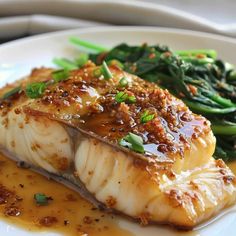 a white plate topped with fish and green beans