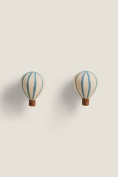 two blue and white striped hot air balloons on a light gray background, one is in the shape of a balloon