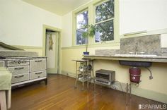 an old fashioned kitchen with wood floors and white walls